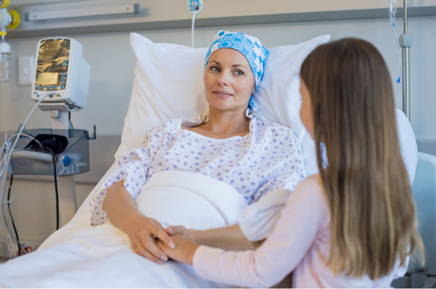 אישה נלחמת בסרטן מחזיקה את ידי בתה