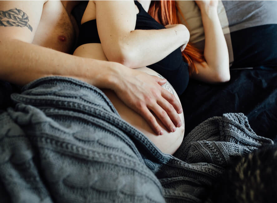 גבר ואישה הריונית שוכבים במיטה - מותר לקיים סקס בהיריון