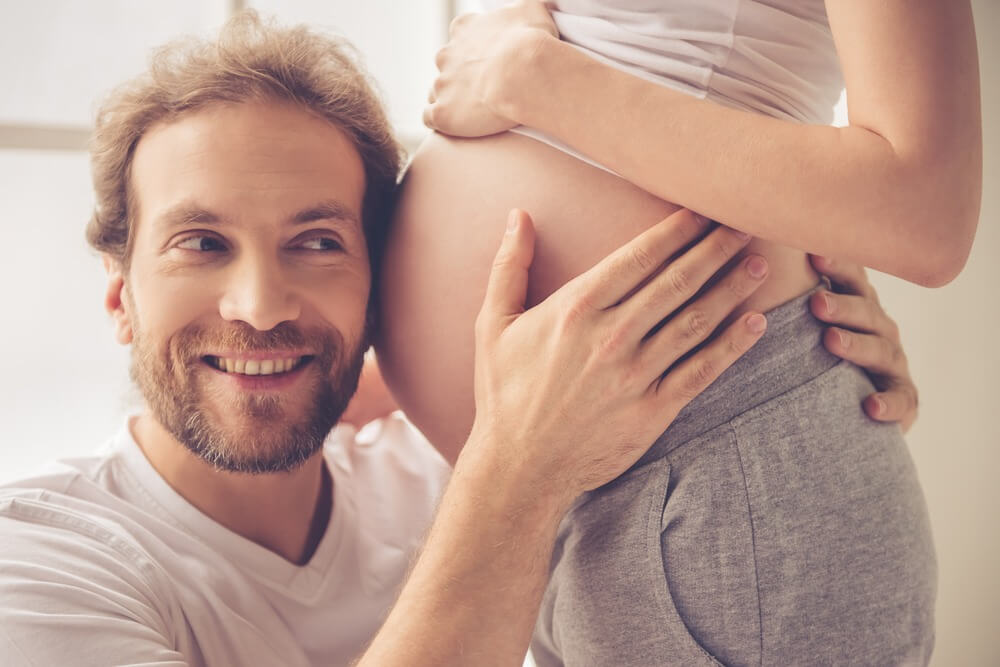 גבר מקשיב לבטן של אישתו ההריונית - דיקור סיני בהיריון