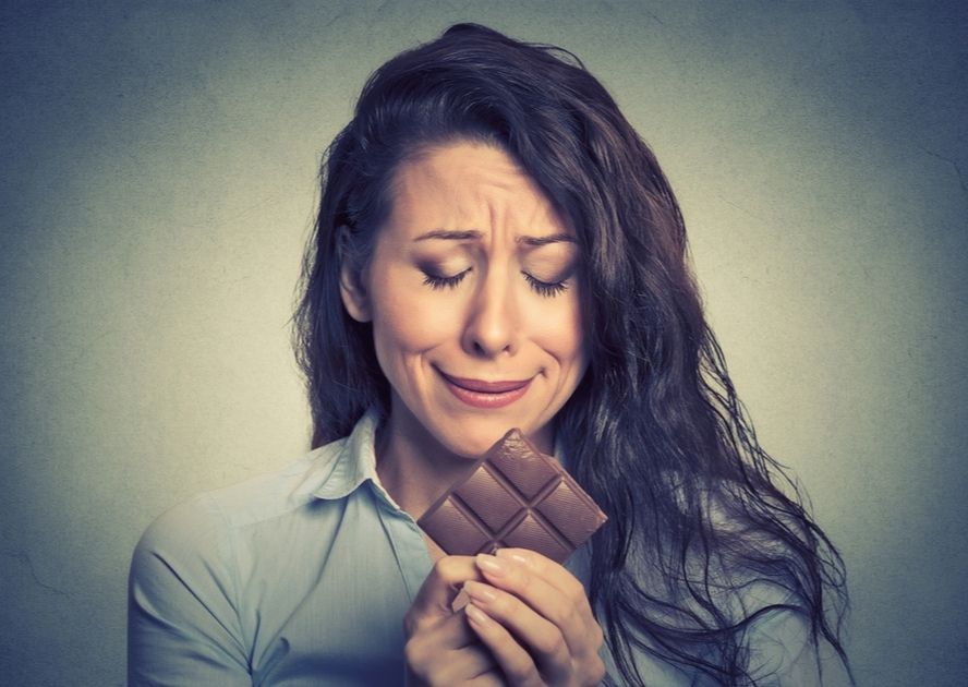 אישה מנסה לעצור עצמה מלאכול שוקולד ולהיגמל מסוכר