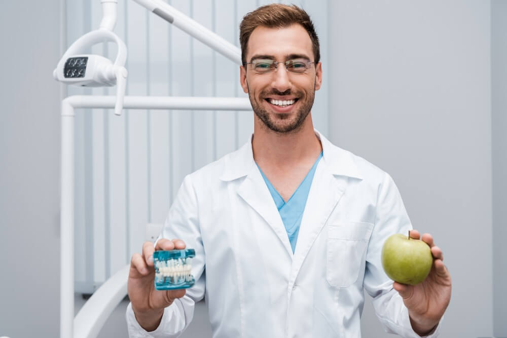 רופא שיניים אוחז בתפוח