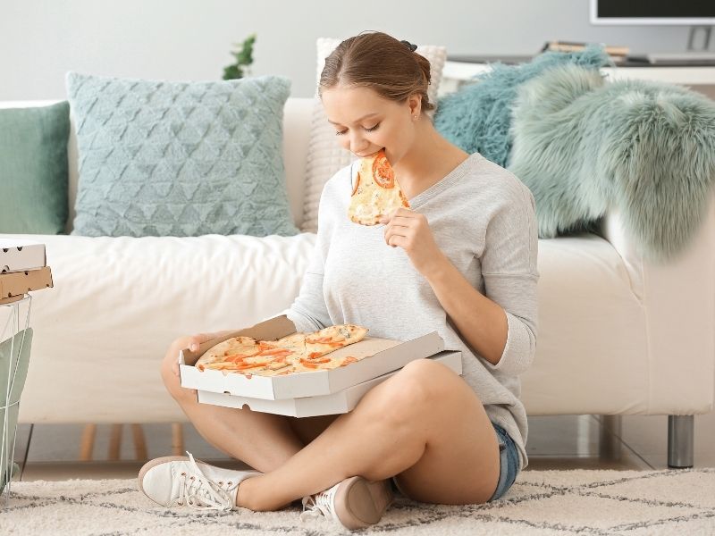 אכילה רגשית אישה אוכלת פיצה