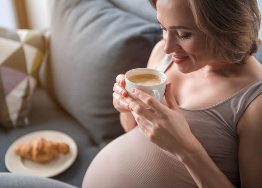 אישה בהיריון שותה קפה