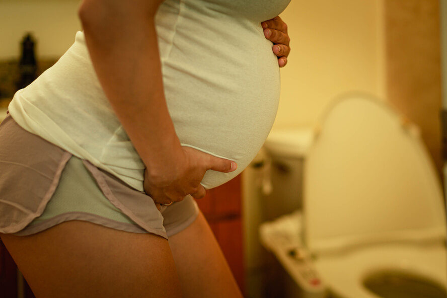 אישה בהיריון בשירותים צריכה פיפי