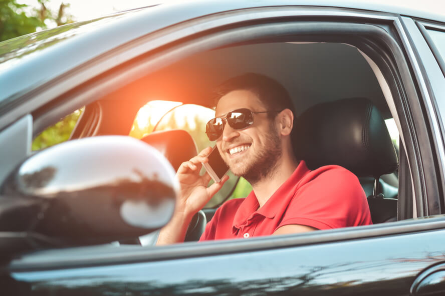 גבר משוחח בטלפון הסלולרי ברכב