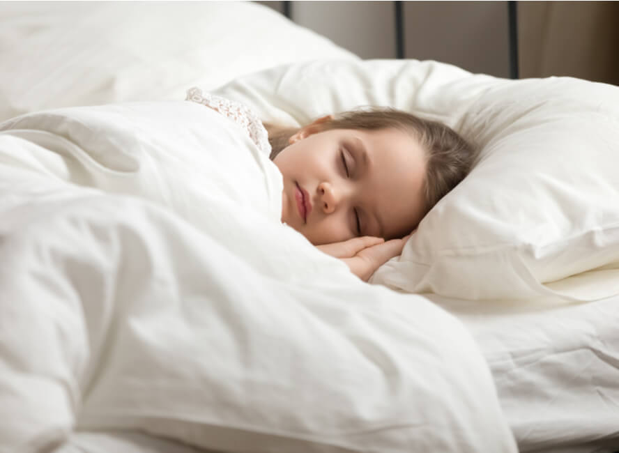 ילדה ישנה בנחת בתוך שמיכה כבדה