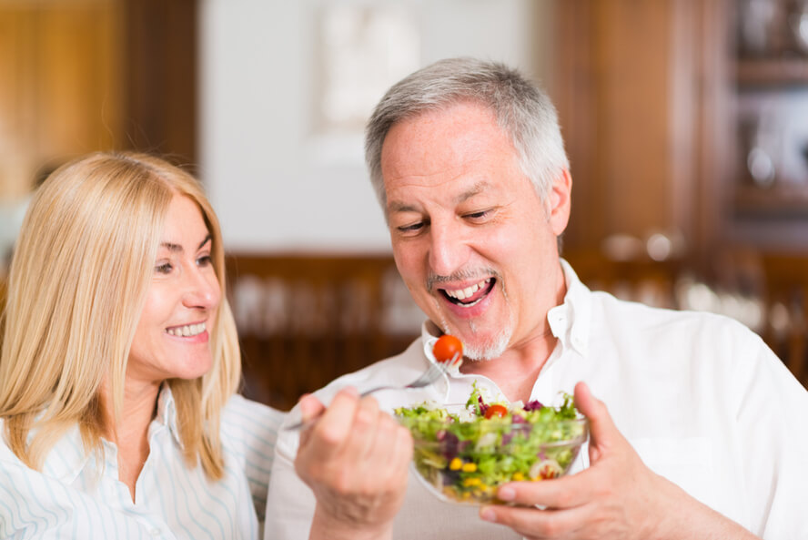 אכילה אינטואיטיבית: גבר אוכל סלט לצד אישה