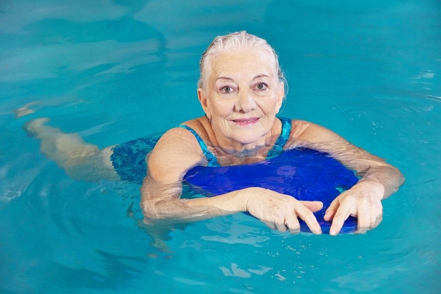 אישה מבוגרת שוחה בבריכה