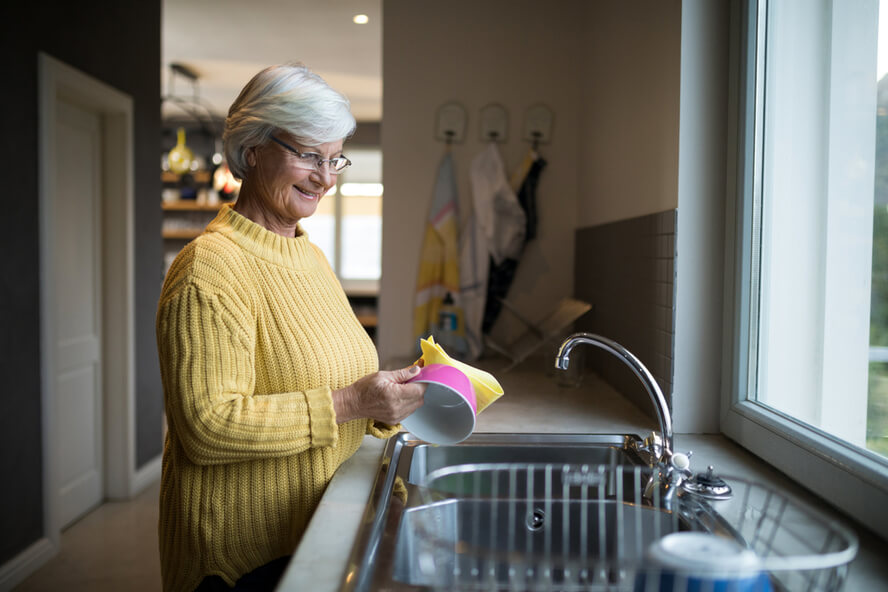 אישה מבוגרת שוטפת כלים