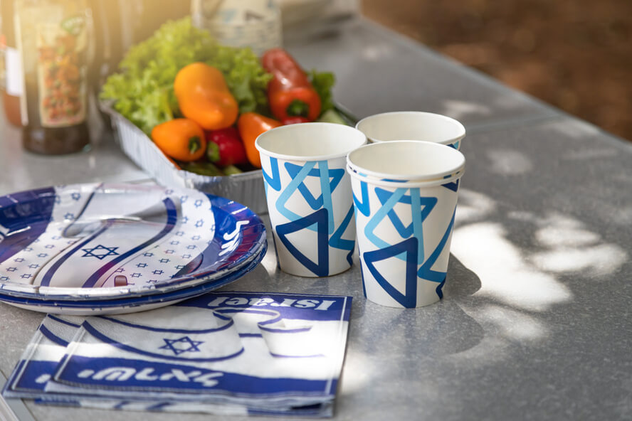  כלי אוכל עם דגלי ישראל על שולחן פיקניק
