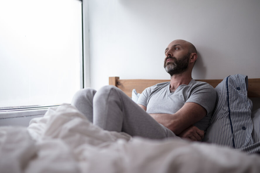 גבר שוכב במיטה וחושב על קיום יחסי מין - בתולים