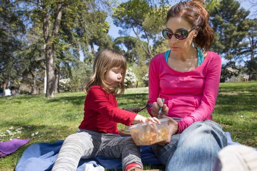 אם ובתה אוכלות פסטה בפארק