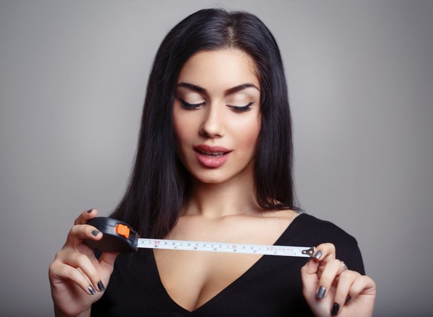 אישה מחזיקה מטר על מנת למדוד את גודל איבר המין - פין