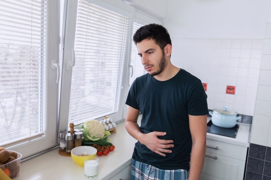 אי סבילות ללקטוז - גבר צעיר סובל מחוסר נוחות לאחר שתיית חלב