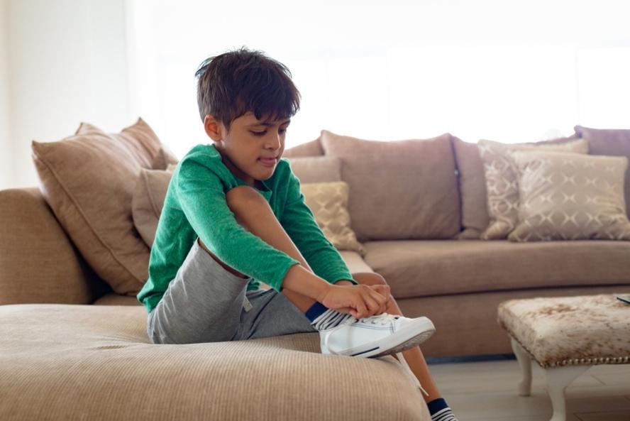 להשאיר נעליים מחוץ לבית: ילד מניח נעליים על הספה