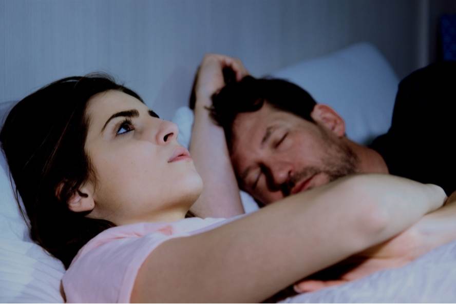 אישה מתוסכלת שוכבת במיטה מדוכאת מינית