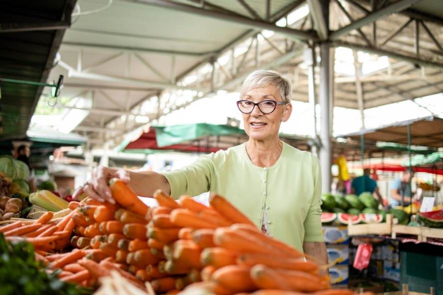 ירקות ופירות להגנת המוח: אישה רוכשת גזר בשוק