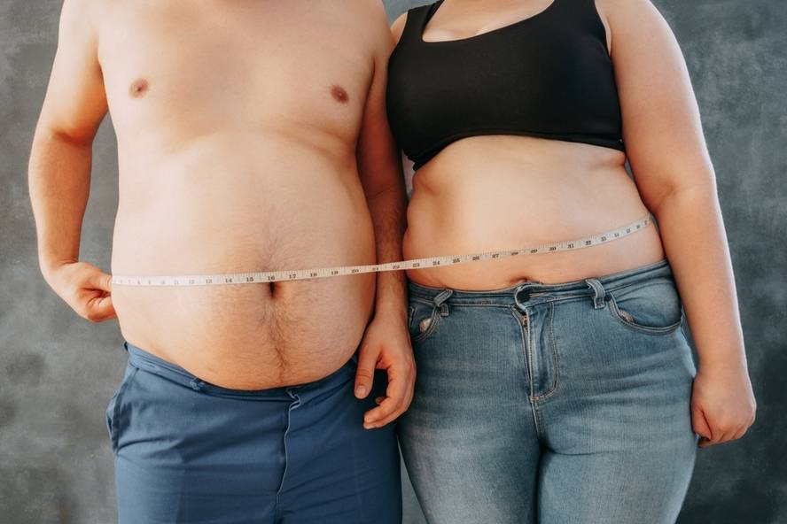 גבר ובחורה מודדים את היקף הבטן, האם קיים שומן בטני?