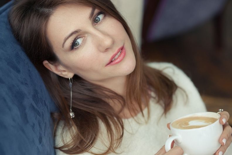 אישה שותה קפה קפוצ'ינו בבית