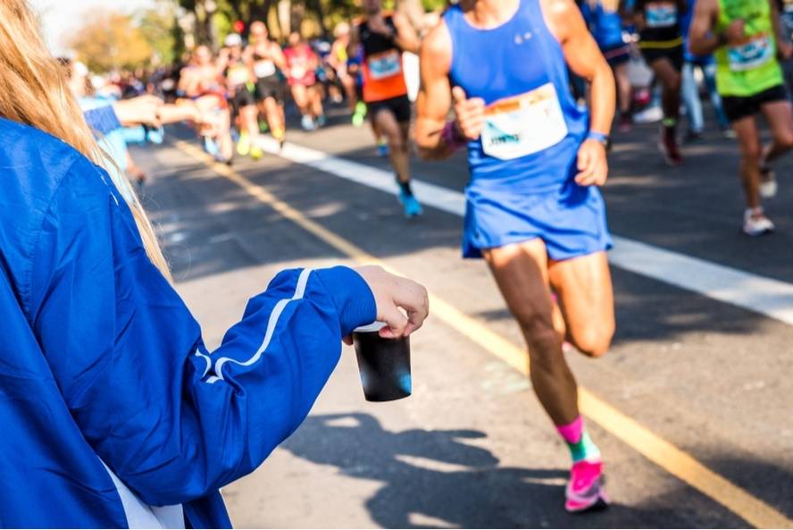 רץ מרתון מקבל משקה אלקטרוליטי