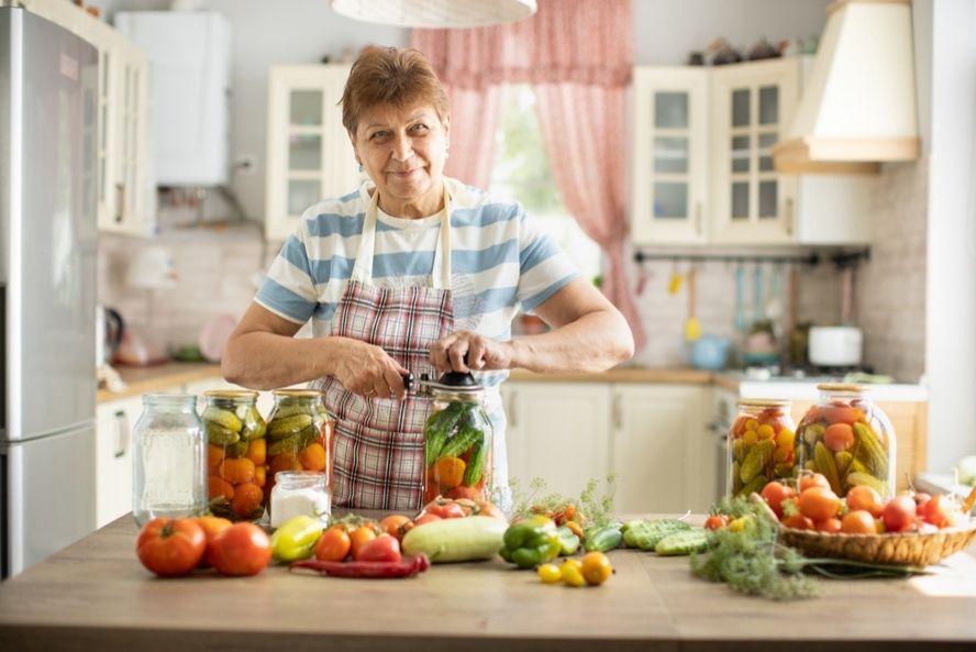 אישה מבוגרת מכינה ירקות מותססים